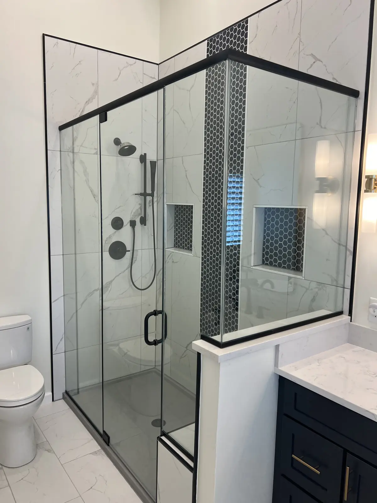 Glass shower and navy vanity in a master bath