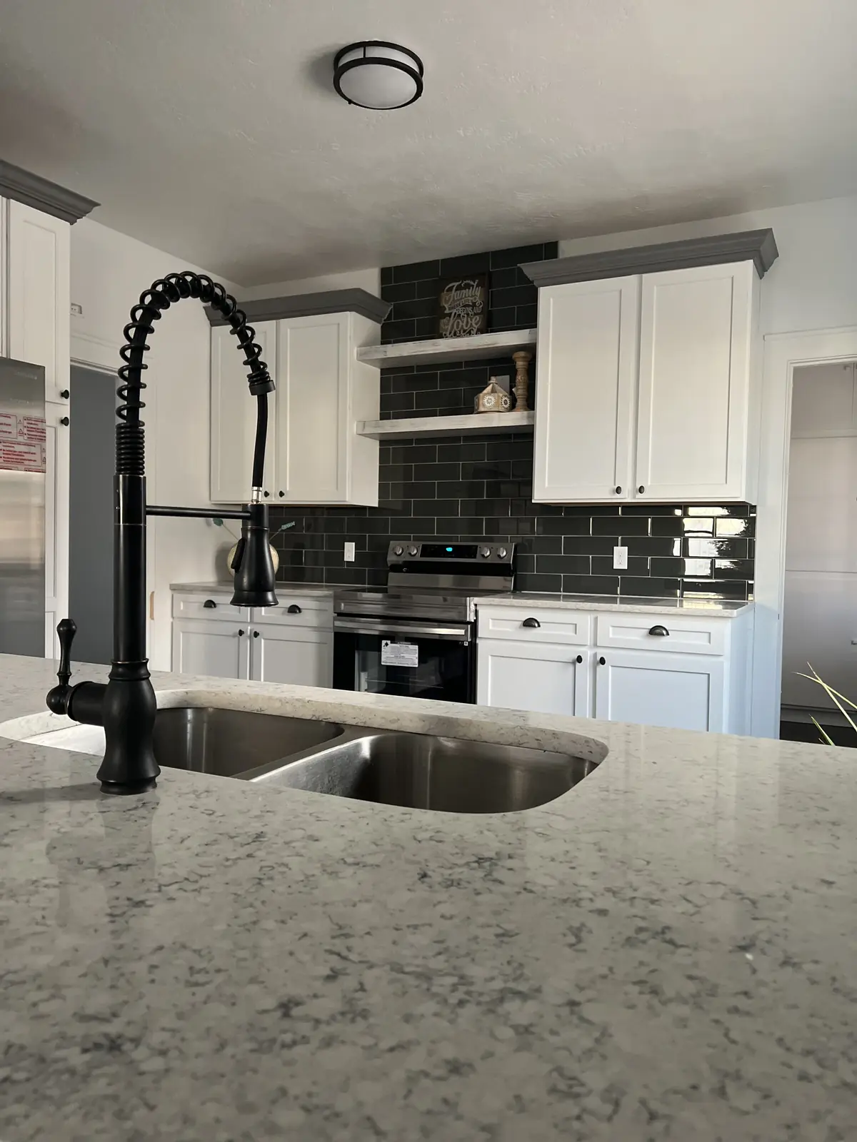 Matte black faucet and quartz counter detail from a KM kitchen
